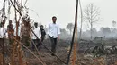 Presiden Joko Widodo atau Jokowi memeriksa kerusakan akibat kebakaran hutan dan lahan (karhutla) di Pekanbaru, Riau, Selasa (17/9/2019). Jokowi ditemani sejumlah pejabat saat meninjau lokasi kebakaran. (Handout/Indonesian Presidential Palace/AFP)