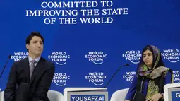 Peraih Nobel Malala Yousafzai mengamati PM Kanada Justin Trudeau disela acara tahunan World Economic Forum (WEF) di Davos, Swiss, Kamis (25/1). PM Trudeau mencuri perhatian dengan kaus kaki yang motif bebek berwarna kuning dan ungu. (AP/Markus Schreiber)
