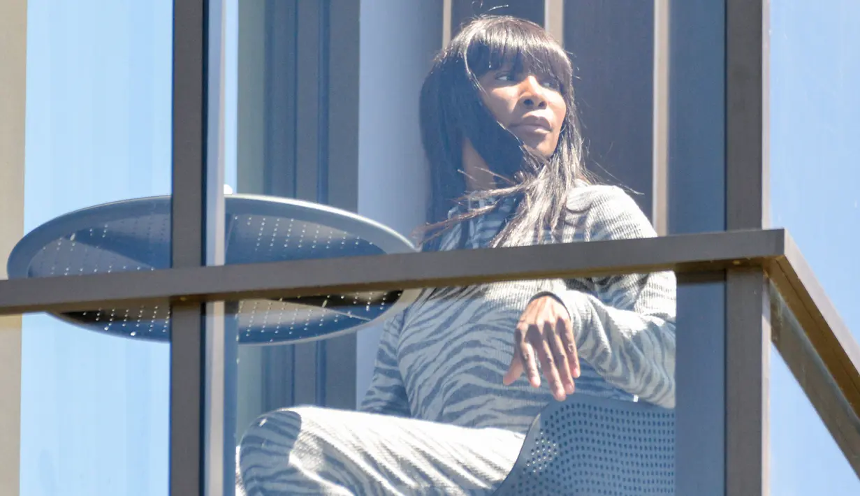 Petenis Amerika Serikat, Venus Williams, bersantai di balkon hotel di Adelaide, Australia, Jumat (22/1/2021). Venus Williams melakukan karantina selama dua minggu sebelum mengikuti ajang Australia Terbuka 2021. (AFP/Brenton Edwards)
