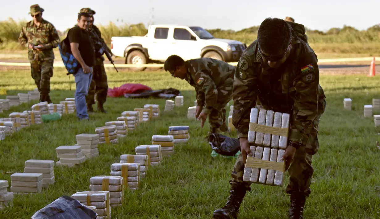 Petugas meletakan satu ton kokain dalam paket yang disita di lokasi Baures saat jumpa pers di Trinidad, El Beni, Bolivia (19/7). Obat terlarang tersebut diduga akan dikirim ke Brasil. (AFP Photo/Ar/Aizar Raldes)