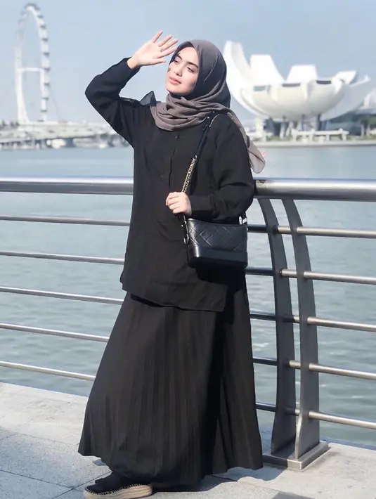 Seleb 23 tahun ini memang dikenal sering mengenakan outfit bernuansa hitam. Meski memilih warna gelap, penampilan Vebby Palwinta tetap terlihat modis. Saat berlibur kali ini, baju dan rok hitam yang dipadukan dengan hijab abu agar terlihat serasi. (Liputan6.com/IG/@vebbypalwinta)