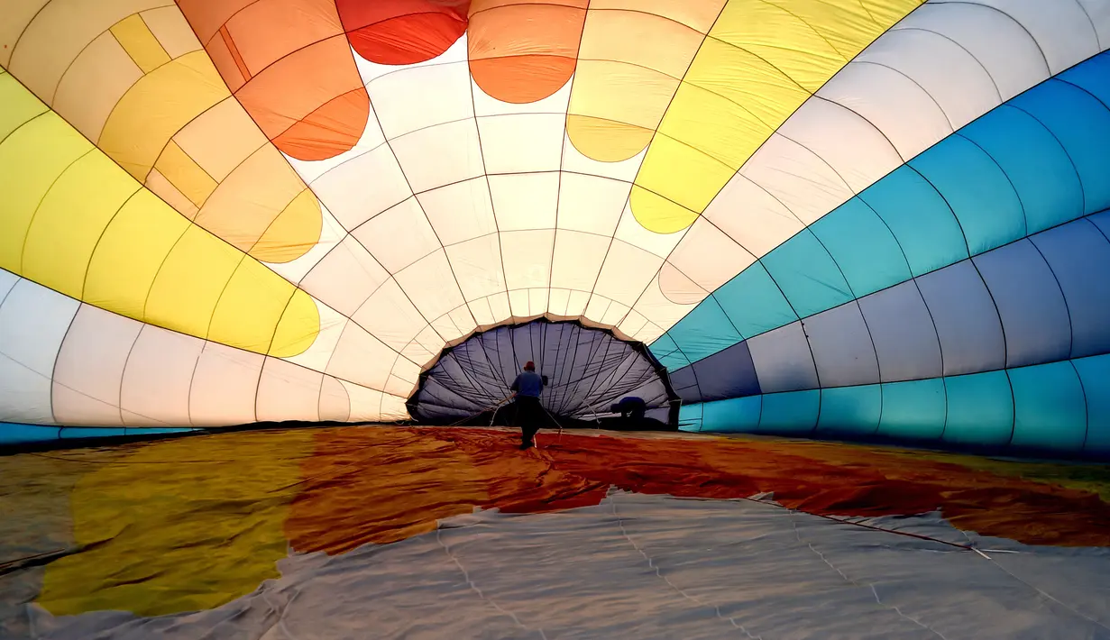 Salah satu tim mempersiapkan balon udara pada festival internasional Sagrantino di kawasan Umbria, Italia, 22 Juli 2018. Puluhan balon udara berkompetisi menghadapi tantangan dalam festival yang memperebutkan piala perak tersebut. (AFP PHOTO/TIZIANA FABI)