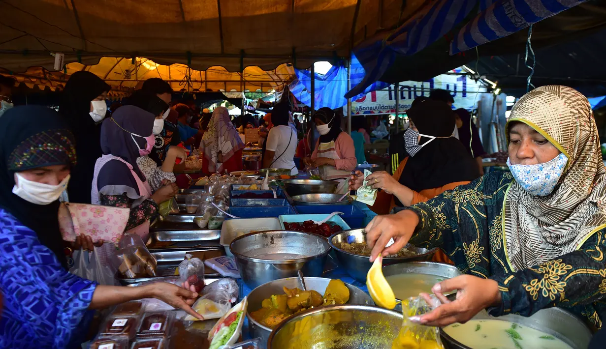 Orang-orang berbelanja di pasar makanan pada hari pertama bulan suci Ramadhan di provinsi Narathiwat di Thailand selatan (24/4/2020). Sejumlah pedagang menjual berbagai makanan selama bulan suci Ramadan di pasar tersebut. (AFP/Madaree Tohlala)