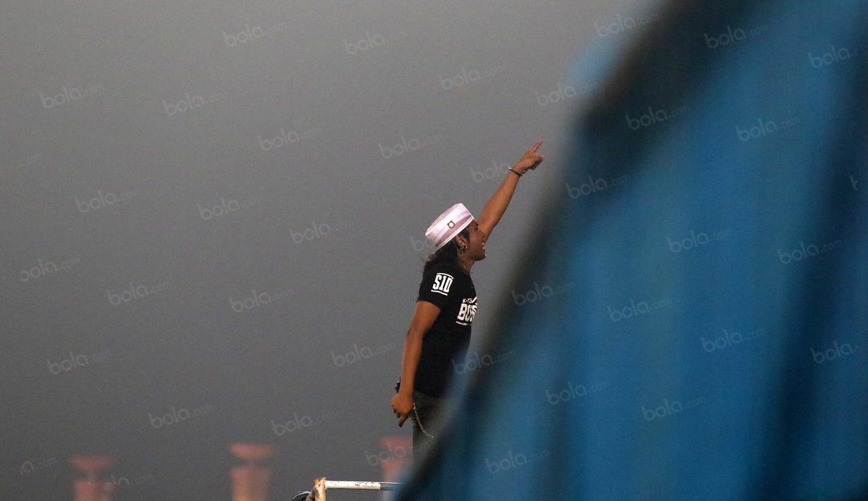 Pemimpin aksi K-Conk Mania memberikan instruksi kepada rekan-rekannya saat mendukung timnya Madura United melawan Persiba Balikpapan pada Torabika SC 2016 di Stadion Gelora Bangkalan, Senin(13/6/2016).  (Bola.com/Nicklas Hanoatubun)