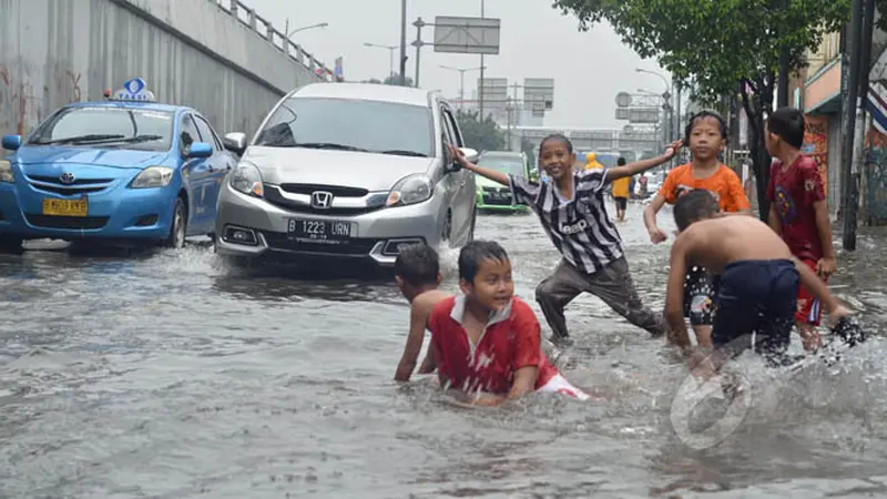 Anak-anak Asyik Bermain Banjir di Jalan Pramuka