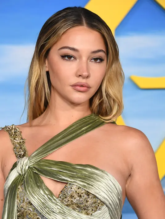 Madelyn Cline berpose saat menghadiri pemutaran perdana "Glass Onion: A Knives Out Mystery" di Academy Museum of Motion Pictures  di Los Angeles, California pada 14 November 2022. Ia melengkapi penampilannya dengan sepasang sandal bertali kaki terbuka berwarna nude. (Jon Kopaloff/Getty Images/AFP)