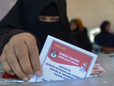 Seorang wanita memasukan kertas suaranya saat latihan pra-pemilihan di Banda Aceh, provinsi Aceh (6/4). Indonesia akan menyelenggarakan Pemilu serentak pada 17 April 2019. (AFP Photo/Chaideer Mahyudin)