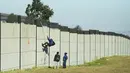 Seorang kolektor besi tua memanjat tembok untuk mencari besi tua untuk didaur ulang di pabrik pengolahan logam di Germiston, timur Johannesburg, Afrika Selatan (30/5/2022). Pengumpul besi tua di area tersebut melompat ke dinding beton untuk mengumpulkan besi tua dan kemudian menjualnya ke toko bekas. (AP Photo/Themba Hadebe)