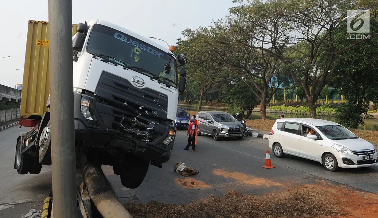 Kendaraan berat kontainer menabrak jalur pembatas pintu masuk tol akses Tanjung Priok di Jalan Raya Cilincing, Jakarta Utara, Sabtu (17/8/2019). Kejadian pada pukul 03.00 dini hari tadi terjadi akibat sopir mengantuk. Tidak ada korban jiwa dalam kejadian ini. (merdeka.com/Arie Basuki)
