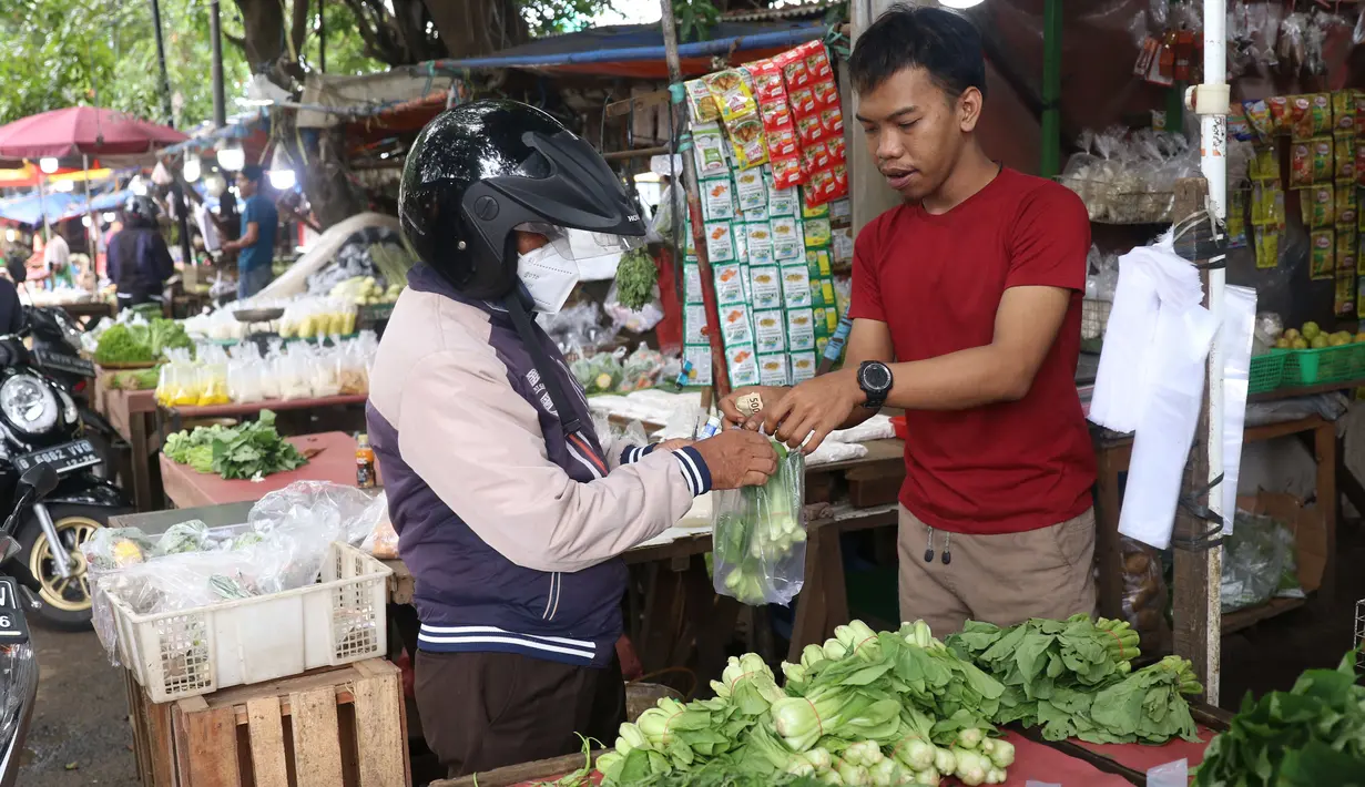 Pedagang melayani pembeli di pasar kawasan Tangerang, Senin (7/2/2022). Ekonom Centre for Strategic and International Studies (CSIS) meminta pemerintah bisa mengantisipasi ketersediaan bahan pokok seiring peningkatan kasus COVID-19 varian Omicron. (Liputan6.com/Angga Yuniar)