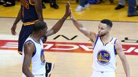 Pemain Golden State Warriors Kevin Durant (35) dan Stephen Curry (30) melakukan selebrasi saat bertanding melawan Cleveland Cavaliers di gim pertama Final NBA 2017 di Oracle Arena di Oakland, California (1/6). (Thearon W. Henderson/Getty Images/AFP)