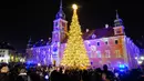 Orang-orang mengabadikan foto pohon Natal yang diterangi lampu di Castle Square di Warsawa, Polandia, pada 5 Desember 2020. Dinyalakannya lampu pohon Natal besar di Castle Square di Warsawa pada Sabtu (5/12) menandai pembukaan resmi musim Natal di Polandia. (Xinhua/Jaap Arriens)