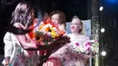 Seorang konstetan bernama Sithembiso Mutukura menerima buket bunga setelah meraih gelar Miss Albino pertama di Zimbabwe (17/3). (AFP Photo/Jekesai Njikizana)