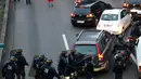 Polisi anti huru-hara tiba ketika pengemudi taksi memblokir jalan dengan membakar ban saat unjuk rasa menentang layanan transportasi VTC seperti Uber, di jalan lingkar di porte Maillot di Paris, Perancis, Selasa (26/1). (AFP PHOTO/Thomas SAMSON)