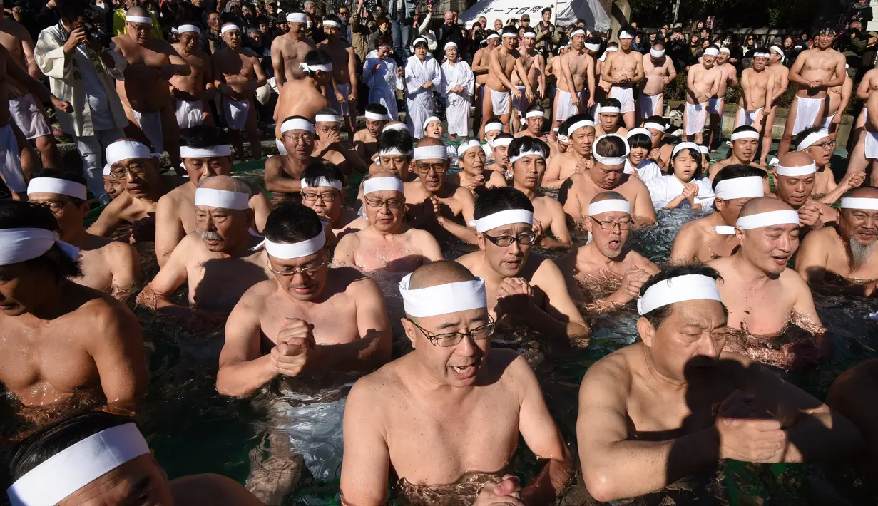 Penganut Shinto berdoa di kolam renang es untuk memurnikan tubuh dan jiwa dalam ritual Upacara Penyucian di Tokyo, Minggu (10/01/2016). (AFP Photo/ Toru Yamanaka)