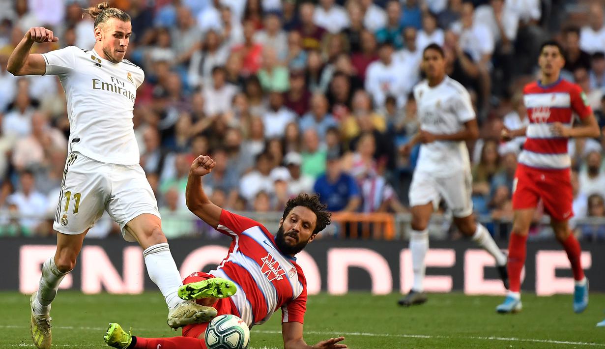 Striker Real Madrid, Gareth Bale, melepas tendangan saat melawan Granada pada laga La Liga Spanyol di Stadion Santiago Bernabeu, Madrid, Sabtu (5/10). Madrid menang 4-2 atas Granada. (AFP/Pierre-Philippe Marcou)