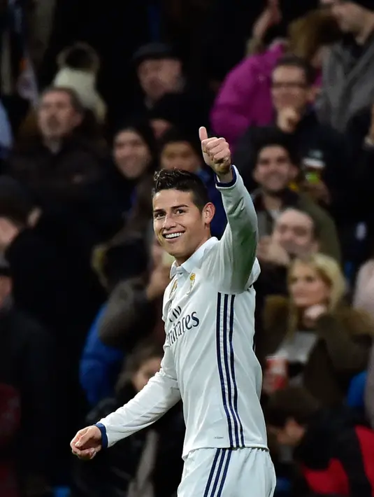 Gelandang Real Madrid, James Rodriguez melakukan selebrasi usai mencetak gol ke gawang Sevilla pada pertandingan pertama babak 16 besar Copa del Rey di Santiago Bernabeu, Spanyol (5/1). Madrid menang atas Sevilla 3-0. (AFP Photo/Gerard Julien)