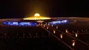 Kuil Wat Dhammakaya dikelilingi oleh lilin yang menyala selama perayaan Makha Bucha di provinsi Pathum Thani, utara Bangkok (16/2/2022). Hari raya ini dirayakan pada saat bulan purnama di tiap bulan ketiga kalender Buddha. (AFP/Jack Taylor)
