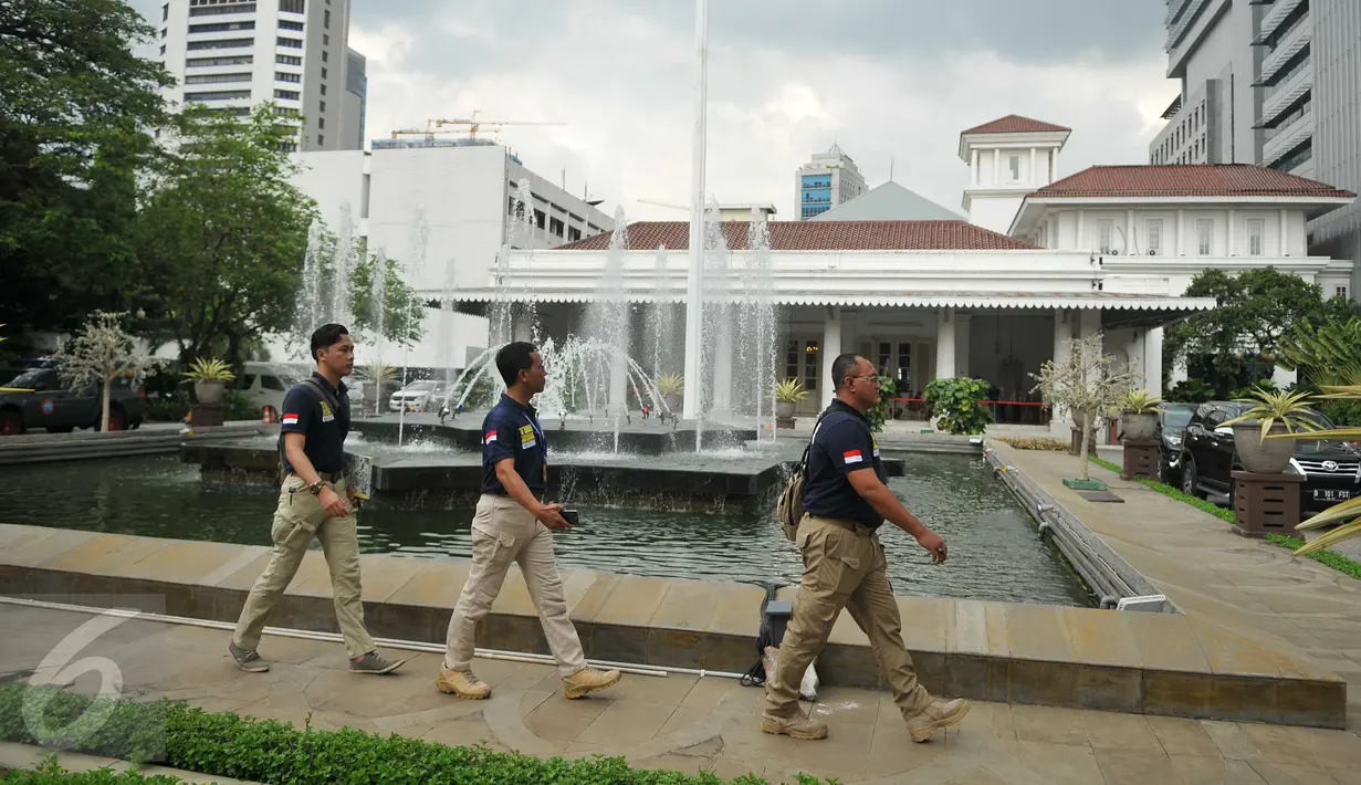Sejumlah anggota polisi berjalan di depan Balai Kota DKI Jakarta, setelah menerima ancaman teror bom dari orang tak dikenal, Rabu (20/7). Saat ini, pengamanan kantor Gubernur Basuki Tjahaja Purnama (Ahok) diperketat. (Liputan6.com/Gempur M Surya)