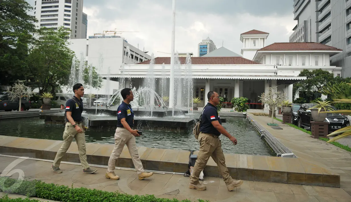 Sejumlah anggota polisi berjalan di depan Balai Kota DKI Jakarta, setelah menerima ancaman teror bom dari orang tak dikenal, Rabu (20/7). Saat ini, pengamanan kantor Gubernur Basuki Tjahaja Purnama (Ahok) diperketat. (Liputan6.com/Gempur M Surya)