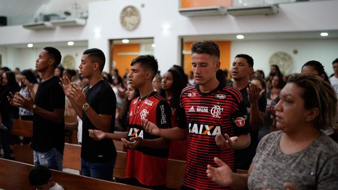 Para pemain muda Flamengo berdoa dalam Misa peringatan untuk para korban kebakaran di sebuah akademi sepakbola Brasil, di Rio de Janeiro, Brasil (8/2). (AP Photo/Leo Correa)