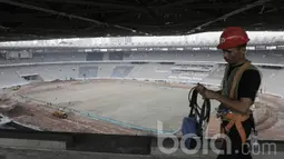 Pekerja menyelesaikan proyek renovasi Stadion Utama Gelora Bung Karno (SUGBK). Selain SUGBK, renovasi menyambut Asian Games 2018 juga meliputi 13 venue lainnya. (Bola.com/M Iqbal Ichsan)
