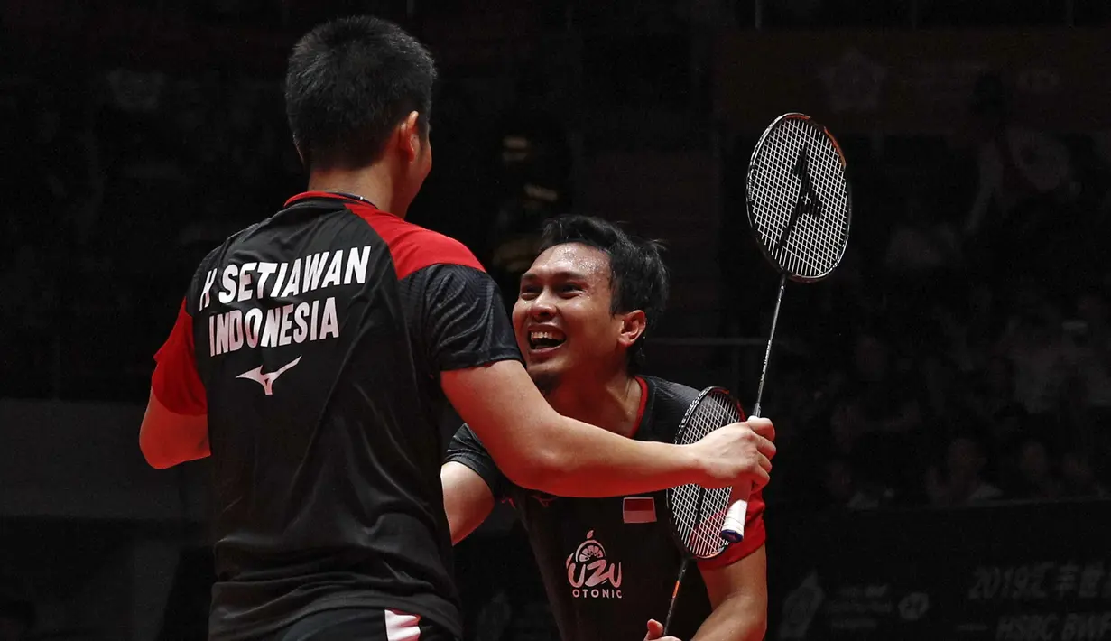 Ganda putra Indonesia  Mohammad Ahsan/Hendra Setiawan berselebrasi usai mengalahkan Hiroyuki Endo/Yuta Watanabe dari Jepang pada final BWF World Tour Finals 2019 di Tianhe Gymnasium, Guangzhou (15/12/2019).  Indonesia sukses membawa pulang satu gelar juara melalui Hendra/Ahsan.  (AP Photo/Andy Wong)