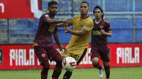 Pemain Bhayangkara Solo FC, Renan Da Silva (tengah) dijaga ketat pemain PSM Makassar, Hasim Kipuw (kiri)  dalam pertandingan matchday ke-2 Babak Penyisihan Grup B Piala Menpora 2021 di Stadion Kanjuruhan, Malang, Sabtu (27/3/2021). Kedua tim bermain imbang 1-1. (Bola.com/Ikhwan Yanuar)