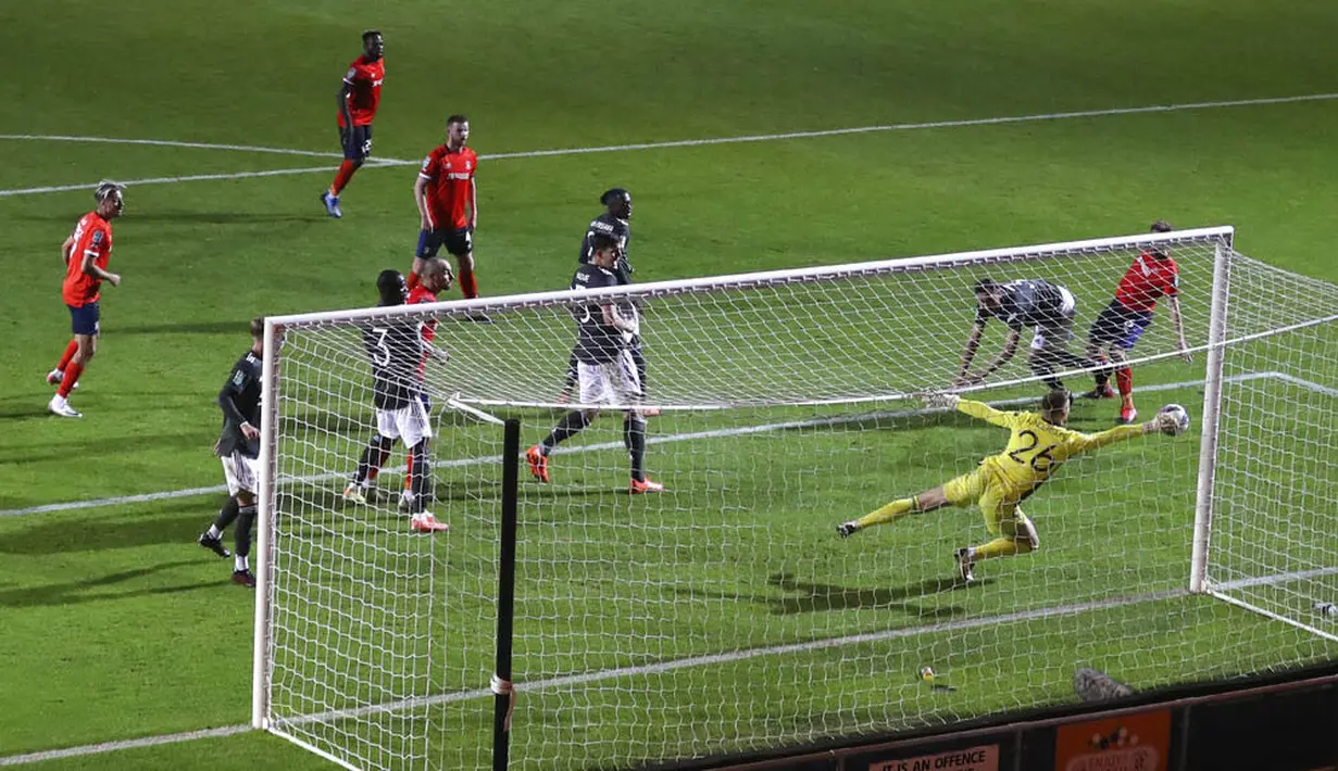 Kiper Manchester United, Dean Henderson, melakukan penyelamatan saat melawan Luton Town pada Piala Liga Inggris di Stadion Kenilworth Road, Rabu (23/9/2020). Setan Merah menang dengan skor 3-0. (Cath Ivill/Pool via AP)