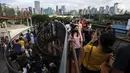 Warga berfoto saat mengisi libur Tahun Baru dengan menikmati pemandangan Kota Jakarta dari Skywalk Senayan Park, Sabtu (1/1/2022). Skywalk Senayan Park kini menjadi salah satu tempat wisata pilihan warga Jakarta lantaran pemandangannya yang instagramable. (Liputan6.com/Johan Tallo)