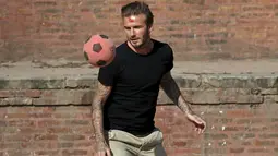 David Beckham mengoper bola ketika melakukan pertandingan amal untuk mengumpulkan dana bagi UNICEF di kota tua Bhaktapur, Nepal, Jumat (6/11). (REUTERS / Navesh Chitrakar)