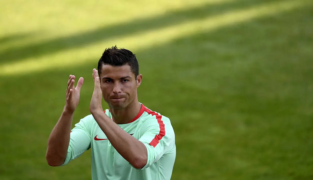 Bintang Portugal, Cristiano Ronaldo, menyapa fans usai latihan jelang Piala Eropa 2016 di Marcoussis, Prancis, Kamis (9/6/2016). (AFP/Francisco Leong)