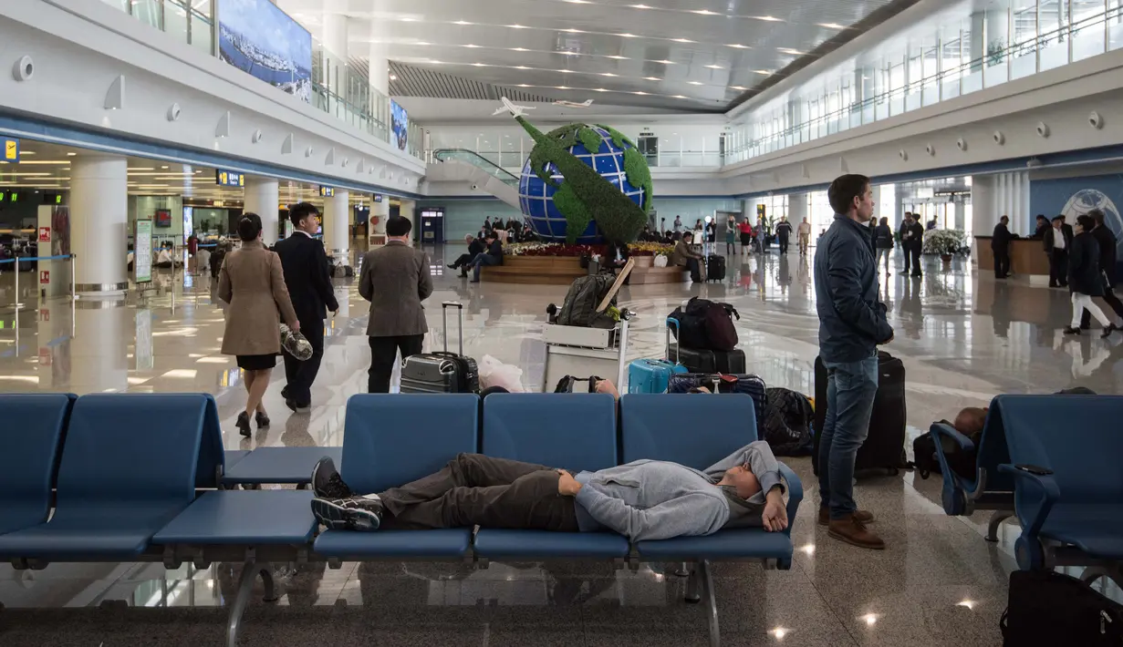 Foto pada 17 April 2017 terlihat para pelancong menunggu jadwal keberangkatan pesawat mereka di bandara Pyongyang, Korea Utara.  (Ed JONES/AFP)