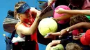 Penonton saat meminta tanda tangan Maria Sharapova usai memenangkan pertandingan putaran ketiga melawan Lauren Davis di turnamen Australia Open 2016 di Melbourne Park, Australia, (22/1). Sharapova menang 6-1, 6-7(5), dan 6-0. (REUTERS/Jason Reed)