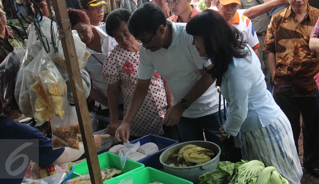 Wagub DKI Jakarta, Djarot Saiful Hidayat (kedua kanan) memilih tahu saat blusukan ke Pasar Petak Sembilan, Jakarta, Sabtu (18/6). Kedatangan Wagub Djarot Saiful disambut gembira para pedagang pasar tersebut. (Liputan6.com/Helmi Afandi)