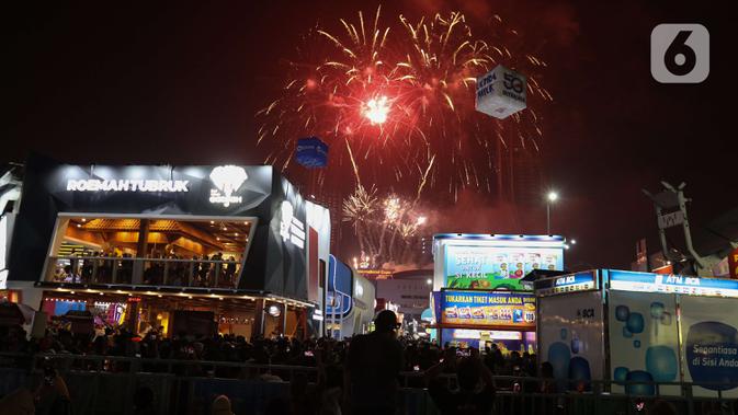 Pengunjung menyaksikan pesta kembang api di langit saat Jakarta Fair ke-53 atau Pekan Raya Jakarta (PRJ) di JiExpo Kemayoran, Jakarta Pusat, Selasa (21/6/2022) malam. Pesta kembang api menggelegar di kawasan PRJ bertepatan dengan HUT Jakarta yang jatuh pada besok, 22 Juni 2022. (Liputan6.com/Herman Zakharia)