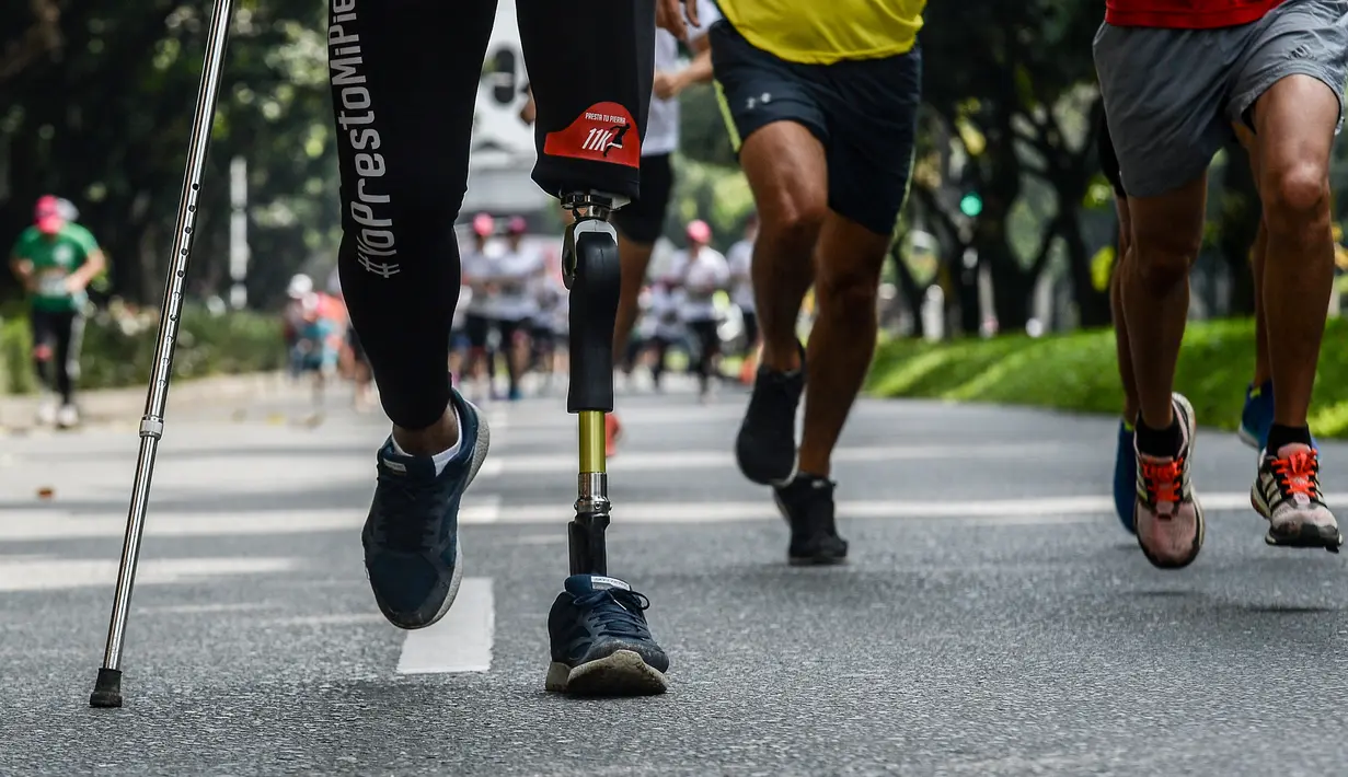 Penyandang difabel bersama warga mengikuti lomba "Lend your leg", di Medellin, Kolombia, Minggu (7/5). Panitia menggelar lomba tersebut untuk mengumpulkan dana bagi tentara dan polisi yang terluka dalam pertempuran. (AFP PHOTO / Joaquin Sarmiento)