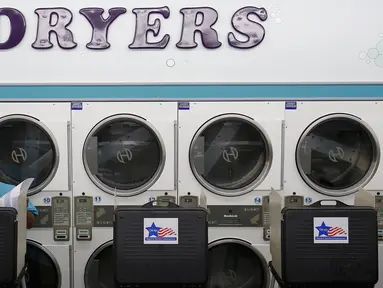 Seorang pria menggunakan hak pilihnya di sebuah tempat cuci pakaian umum, Su Nueva Lavanderia, yang dijadikan lokasi tempat pemungutan suara (TPS) pemilihan presiden Amerika Serikat (Pilpres AS) di Chicago, Illinois, Selasa (8/11). (REUTERS/Jim Young)