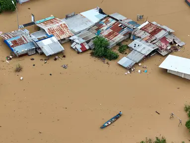Foto udara menunjukkan seorang warga mengayuh perahunya di air banjir yang melanda rumah-rumah terendam di Kota Tuguegarao, Provinsi Cagayan, di utara Manila pada 10 November 2025, setelah sungai meluap akibat hujan deras yang disebabkan oleh Topan Super Fung-wong. Beberapa hari usai terjangan Topan Kalmaegi yang menewaskan lebih dari 200 orang di Filipina, negara itu kembali diterjang badai lain yang lebih kuat. (John DIMAIN/AFP)