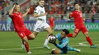 Kiper Timnas Indonesia, Ernando Ari Sutaryadi berhasil menangkap bola dari ancaman striker Vietnam, Nguyen Van Toan pada laga kedua Grup D Piala Asia 2023 di Abdullah Bin Khalifa Stadium, Doha, Qatar, Jumat (19/1/2024). (AFP/Karim Jaafar)