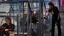Staf menyajikan minuman kepada pelanggan dalam kabin kaca berkonsep "quarantine greenhouses" selama uji coba, ketika Belanda berjuang melawan penyebaran COVID-19, di restoran Mediamatic, Amsterdam pada 5 Mei 2020. (AP/Peter Dejong)