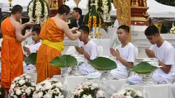 Biksu mencukur rambut anak-anak, yang diselamatkan dari gua di Thailand, pada upacara pentahbisan di Kuil Wat Phra That Doi Wao, Chiang Rai, Selasa (24/7). 11 dari 12 remaja itu menjalani ritual menjadi biksu. (Panumas Sanguanwong/THAI NEWS PIX/AFP)