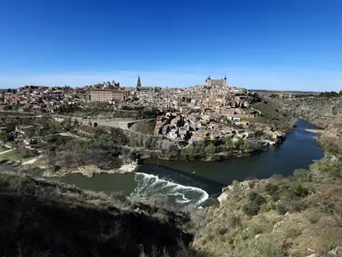 Foto yang diambil pada tanggal 25 Maret 2023 ini menunjukkan pemandangan umum kota tua Toledo, yang terdaftar sebagai Situs Warisan Dunia UNESCO, yang berbatasan dengan Sungai Tagus. (Photo by Thomas COEX / AFP)