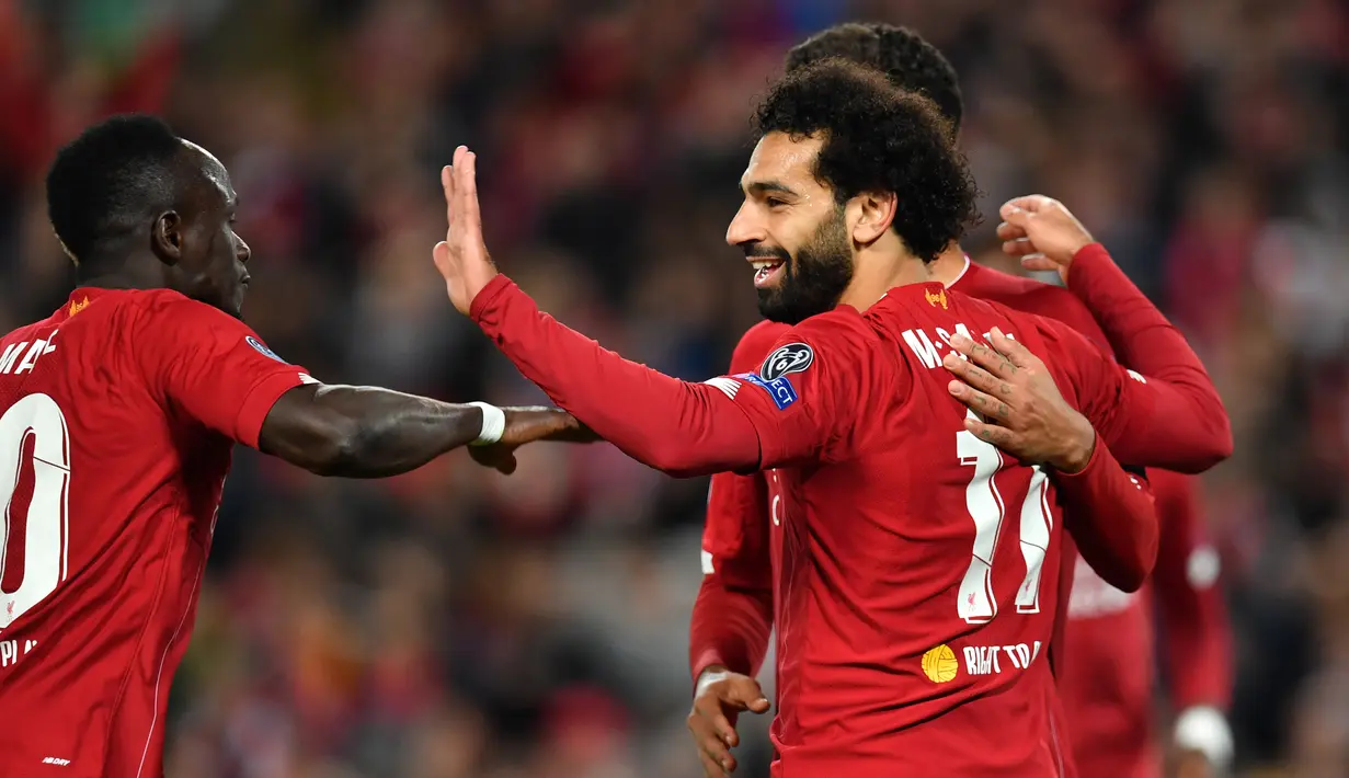 Para pemain Liverpool merayakan gol yang dicetak Mohamed Salah ke gawang Salzburg pada laga Liga Champions di Stadion Anfield, Liverpool, Rabu (2/10). Liverpool menang 4-3 atas Salzburg. (AFP/Paul Ellis)