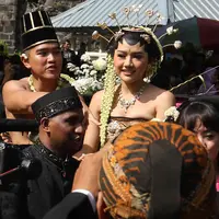 Pasangan pengantin Kaesang Pangarep dan Erina Gudono menaiki kereta saat prosesi kirab Ngunduh Mantu di kawasan Selamet Riyadi, Solo, Jawa Tengah, Minggu (11/12/2022). Kirab ngunduh mantu pernikahan putra bungsu Presiden Joko Widodo, Kaesang Pangarep dan istrinya Erina Gudono yang dimulai dari Loji Gandrung menuju Pura Mangkunegaran tersebut disaksikan ribuan masyarakat Solo dan sekitarnya. (Liputan6.com/Herman Zakharia)