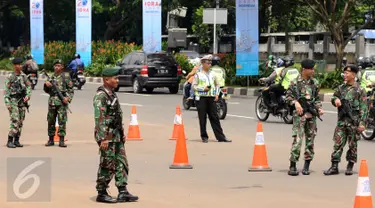 Petugas pengamanan gabungan berjaga di sekitar pintu masuk kawasan Gelora Bung Karno, Jakarta, Senin (6/3). Pengamanan ini terkait pelaksanaan KTT IORA 2017 yang digelar di Jakarta Convention Center 5-7 Maret. (Liputan6.com/Helmi Fithriansyah)