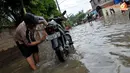 Selain mencari ikan, genangan air dimanfaatkan warga untuk mencuci motor (Liputan6.com/Andrian M Tunay)