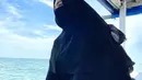 Ria Ricis mengunggah potret dirinya sedang duduk di atas kapal. Ia terlihat mengenakan busana terusan hitam. Mengenakan kerudung serda cadar senada pun membuatnya menuai pujian. (Liputan6.com/IG/@riaricis1795)