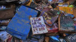 Buku-buku rusak terlihat di jalan setelah hujan lebat membanjiri toko buku di Petropolis, Brasil, 19 Februari 2022. Sebanyak 136 jenazah telah diidentifikasi hingga kini, menurut pejabat pertahanan sipil, di kota wisata yang biasanya indah, sekitar 60 km utara Rio de Janeiro. (MAURO PIMENTEL/AFP)