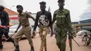 Aparat kepolisian menangkap pemuda yang masih berkeliaran di Kampala, Uganda (26/3/2020). Pemerintah setempat juga menutup seluruh pintu perbatasan, kecuali untuk barang terbatas dan penerbangan darurat resmi sebagai upaya menekan penyebaran Covid-19. (AFP/Badru Katumba)